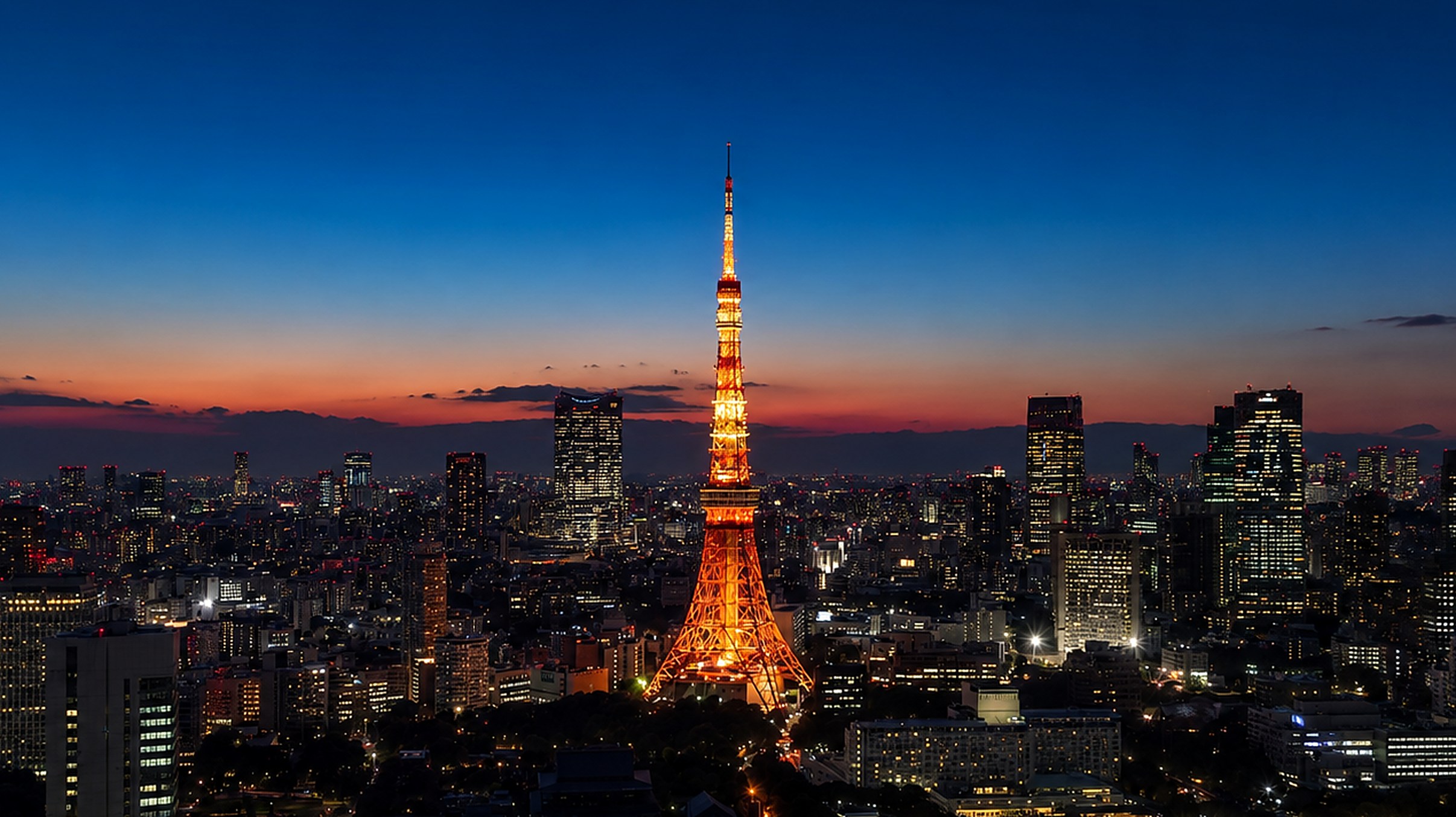 夜景のビル群の中央に赤く輝く東京タワー